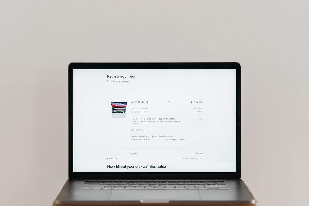 Ordinateur portable minimaliste affichant une page de paiement en ligne sur fond blanc, parfait pour un contexte technologique.